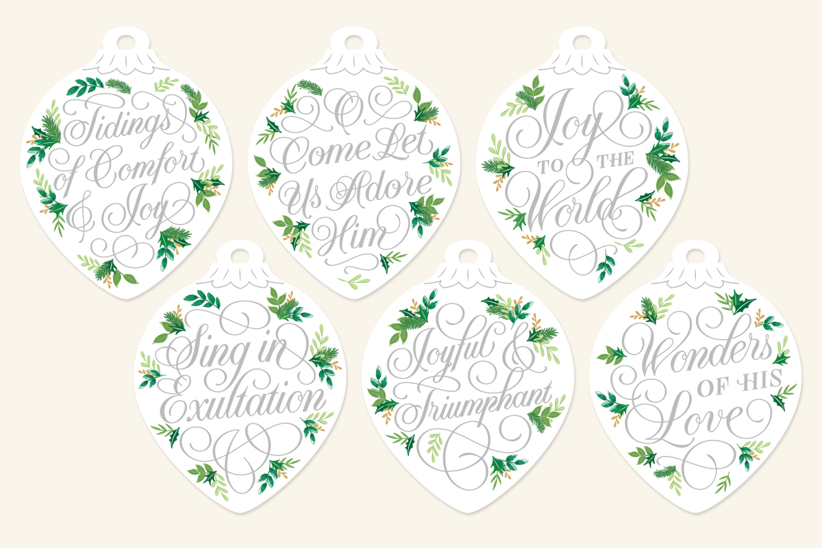 Silver script Christmas ornaments with hand-lettered carol lyrics