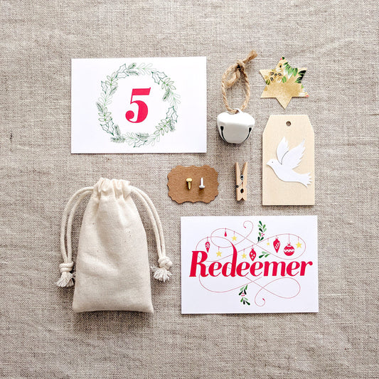 Names of Jesus Advent Calendar cards and accessories laid out on hessian, showing Redeemer card, linen bag and wooden peg